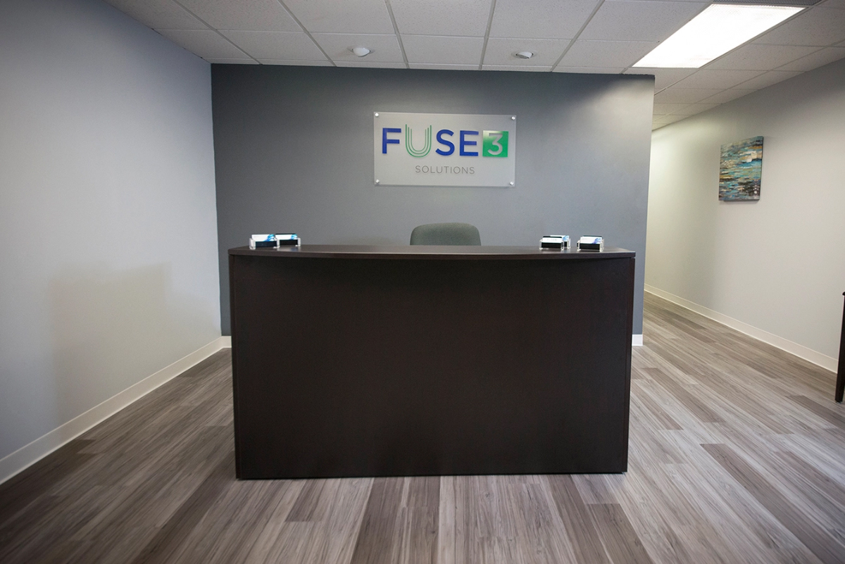 Fuse3 Solutions sign over a desk in a modern office