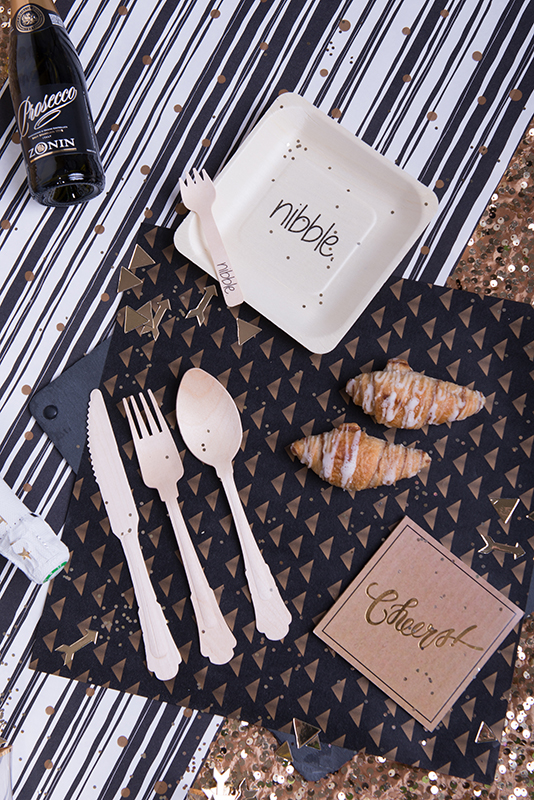 nibble plate cheers napkin disposable cutlery laid out on New Years themed paper