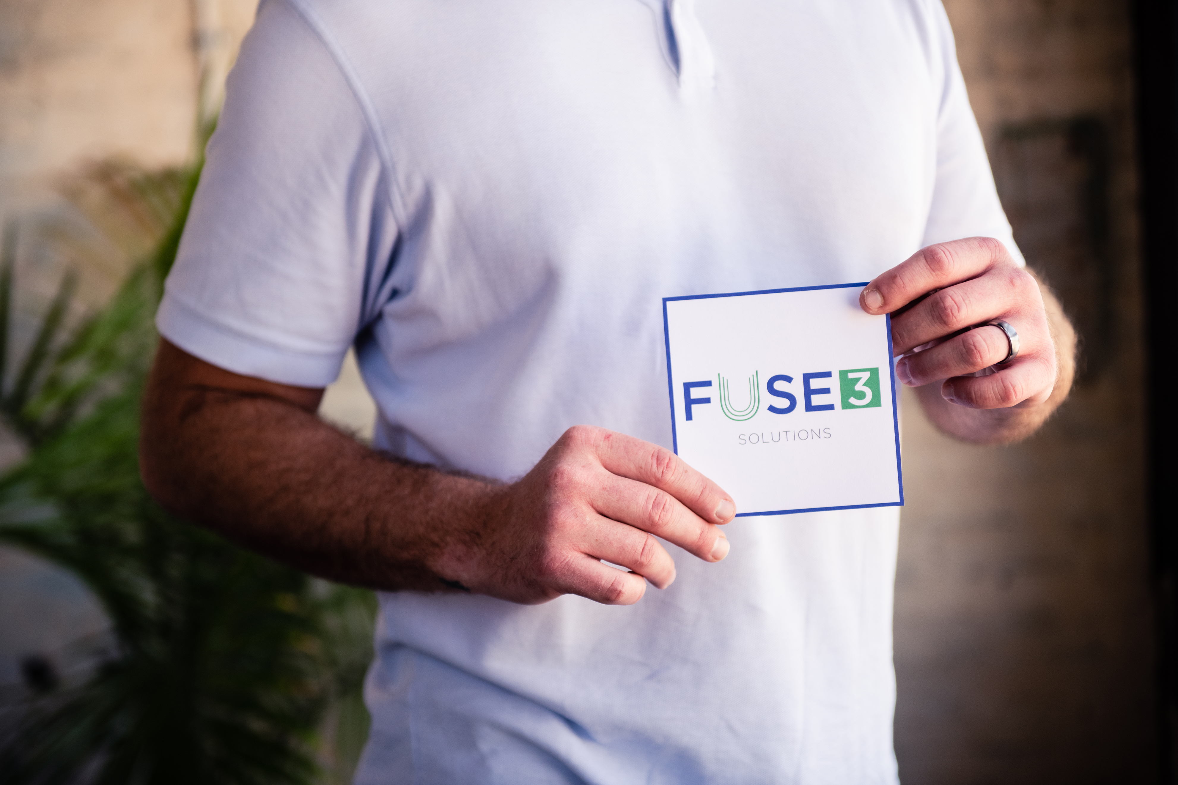 man holding card with Fuse3 Solutions logo printed