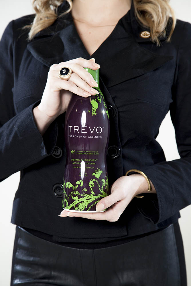 woman holding bottle of Trévo