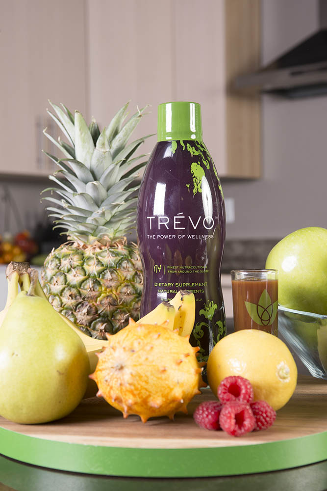 bottle of Trévo on counter with fruit around it