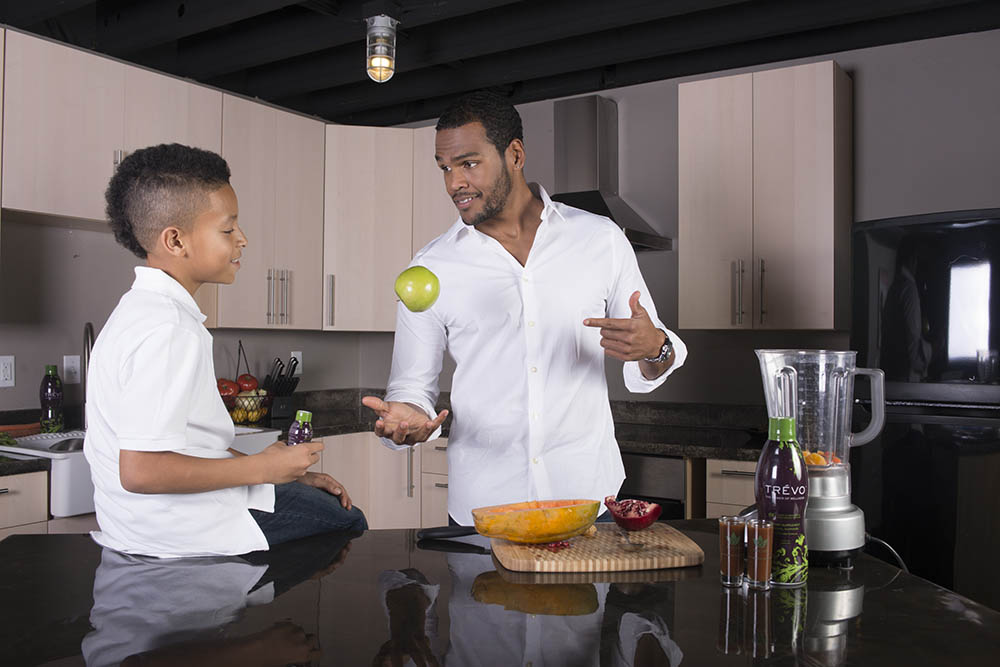 father and son in kitchen with bottle of Trévo on counter