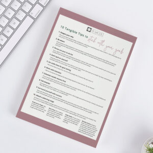 A pink sheet of paper with 10 Tangible Tips for Sticking with Your Goals, if you want to change your life.