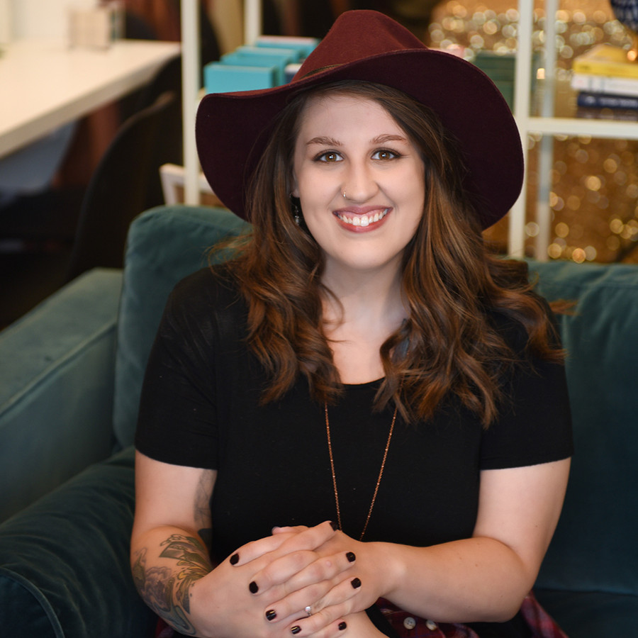 A woman wearing a hat sitting on a couch at a nonprofit site giveaway.