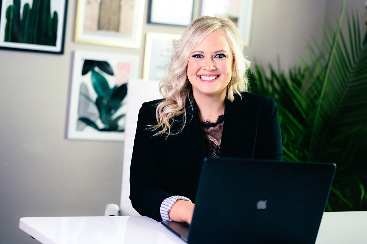 A woman passionately working on her laptop at a desk, completely engrossed in her business.