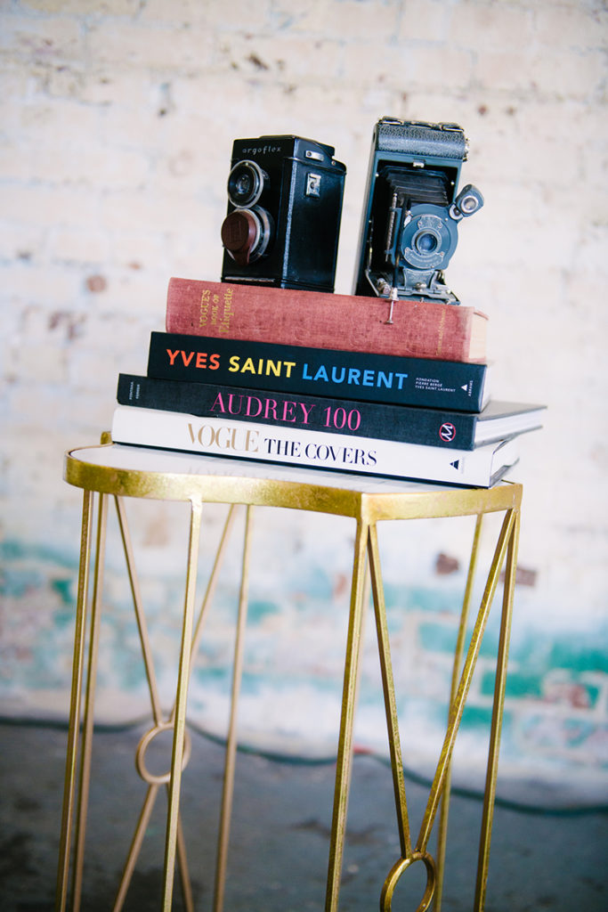 A table with books and a camera on it, perfect for branding mini shoots.
