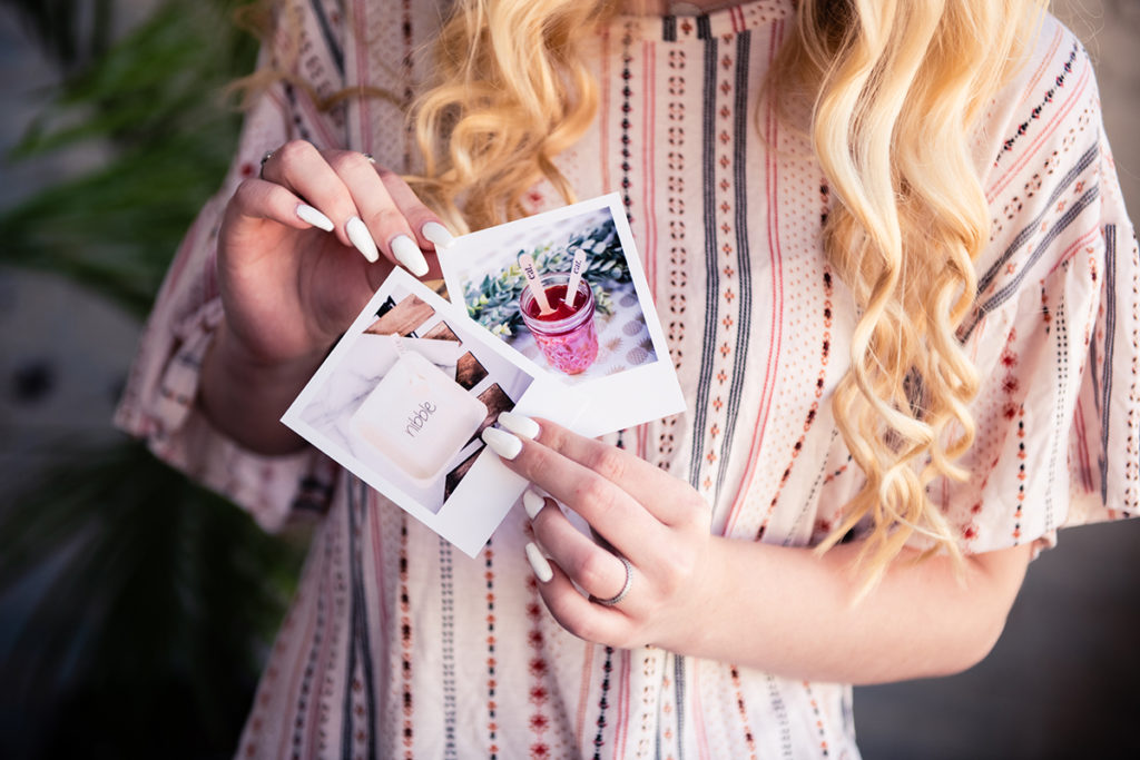 A woman holding up a photo of a polaroid during a branding mini shoot.