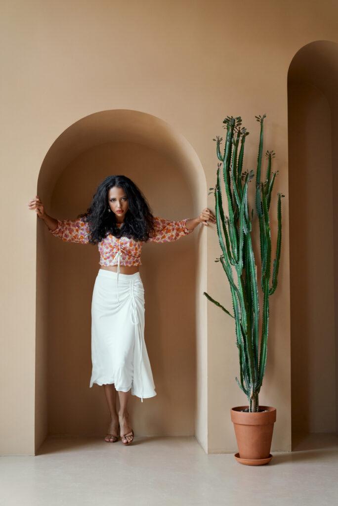 A woman showcasing her personal branding with a potted cactus beside her.