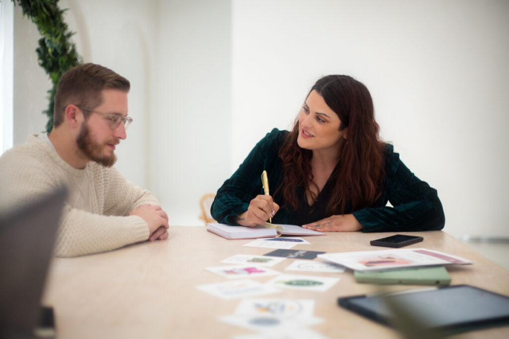 A woman and a man sitting at a table in an office, discussing links.