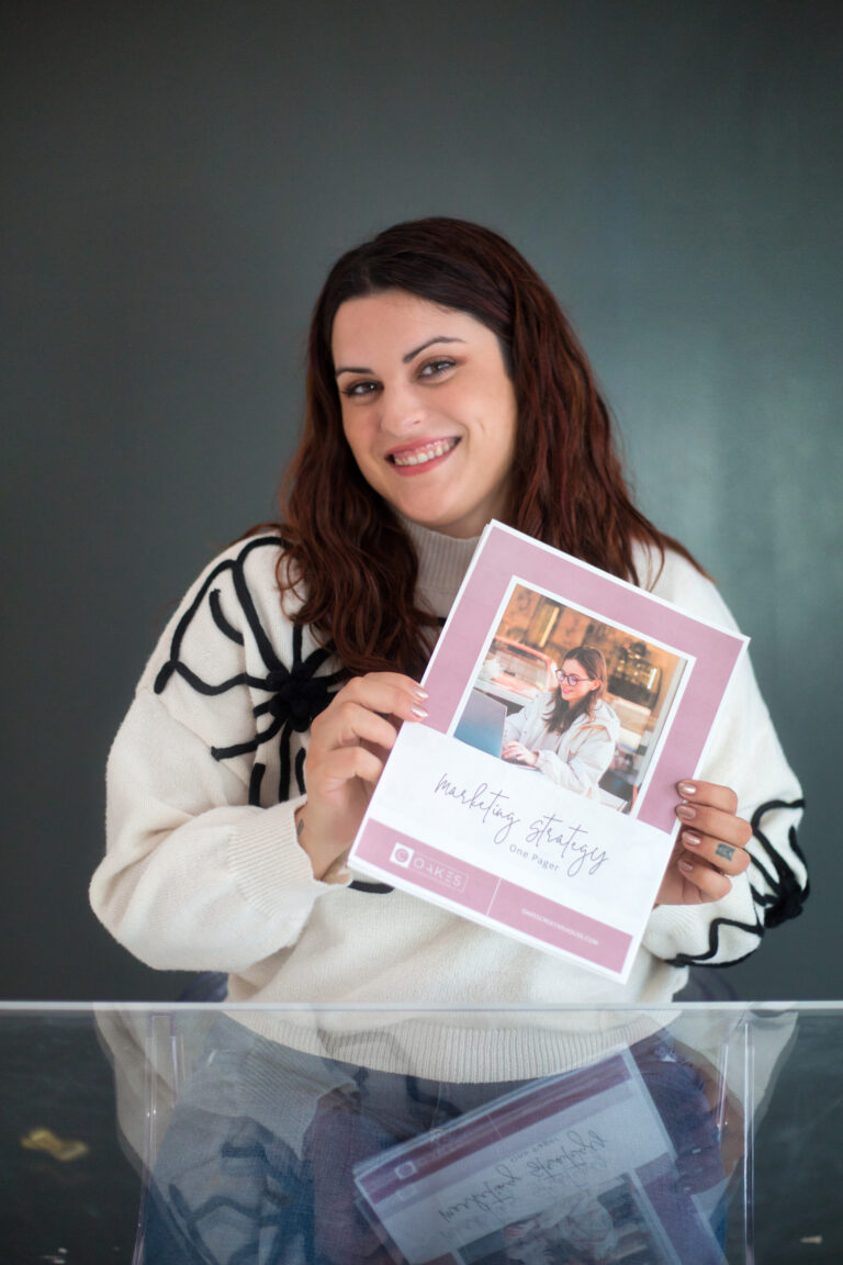 A woman holding up a photo book as part of her marketing strategy.