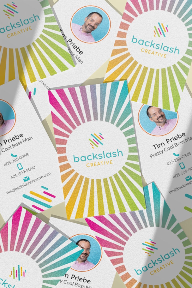 Assorted business cards for "backslash creative" featuring colorful radial designs and photos of employees.
