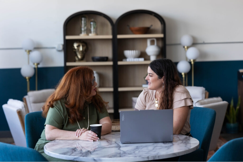 Two women engaging in a meeting, highlighting the return of in-person connection as brand trends in 2025.