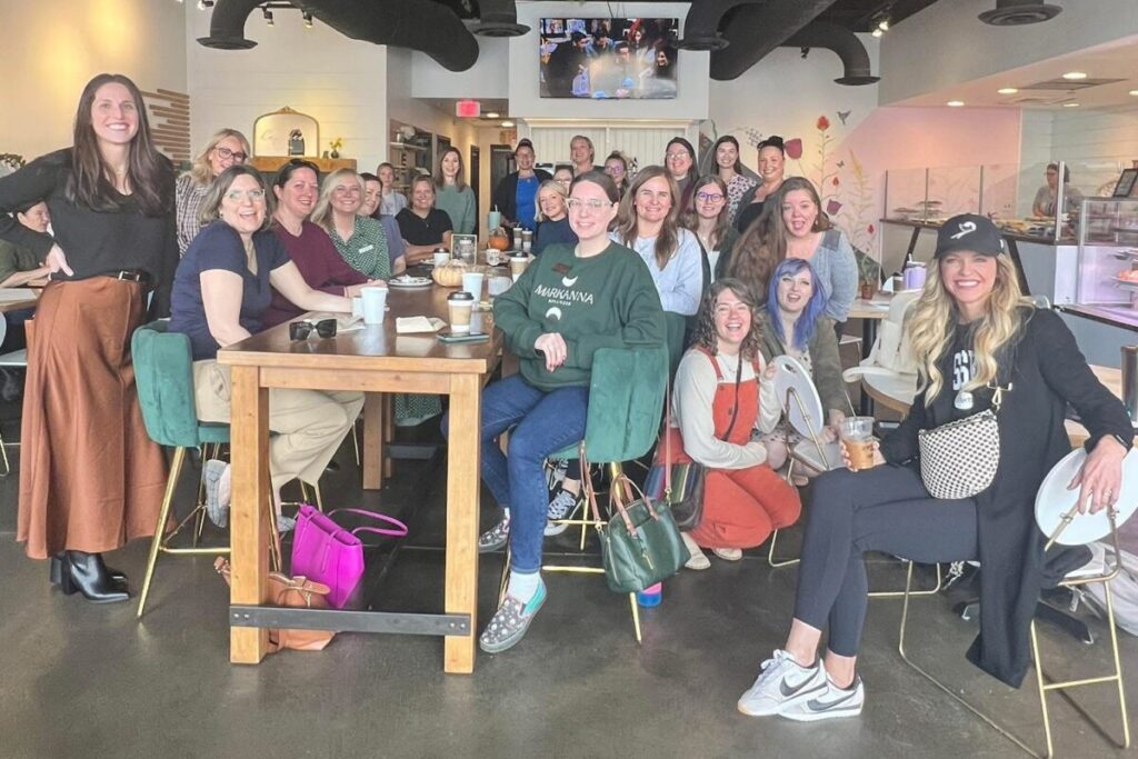 Community members gathered at a local coffee shop event hosted by Oakes Creative House, highlighting relationship-building, networking, and authentic community connection.