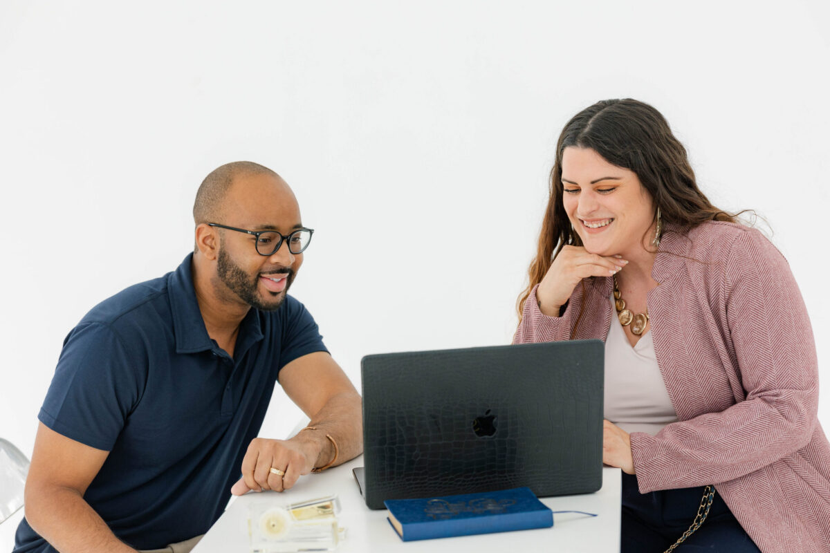 Two professionals reviewing digital marketing strategy and SEO vs. social media planning to support long-term marketing growth and search engine optimization.