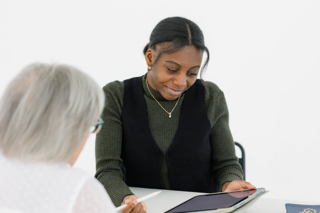Professional reviewing digital marketing analytics and SEO strategy on a tablet during a collaborative planning session focused on long-term marketing growth.
