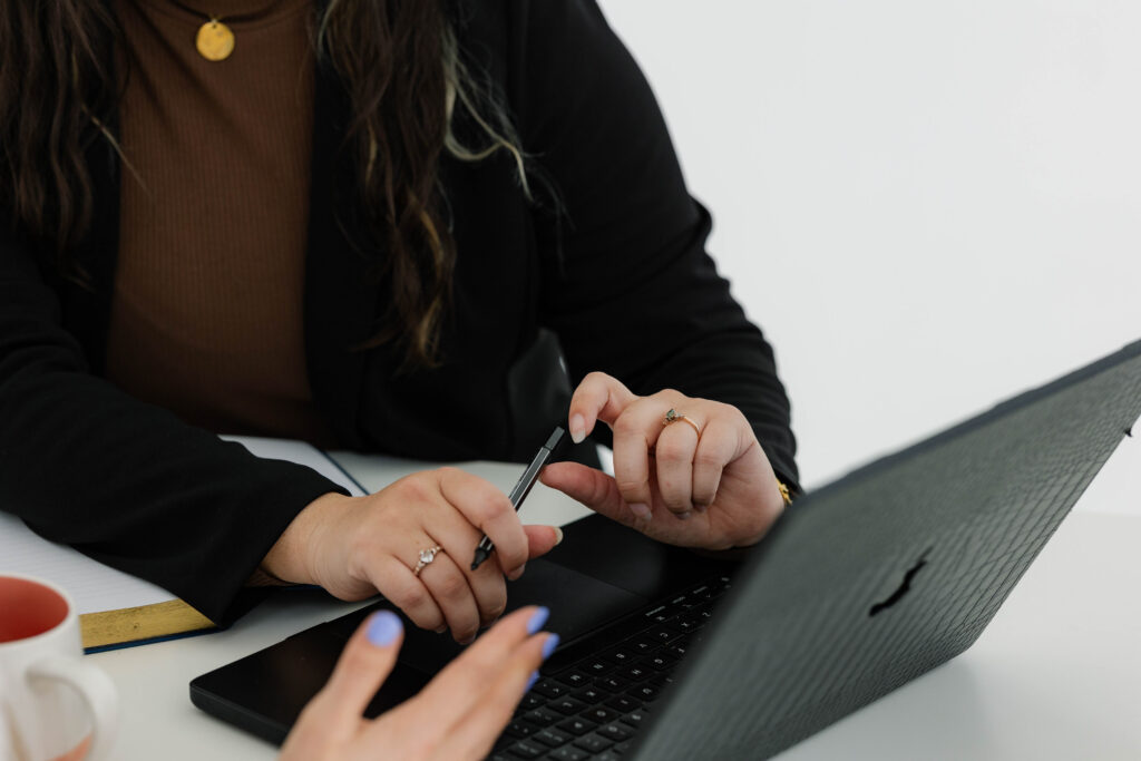 Close-up of a collaborative marketing strategy session at Oakes Creative House featuring a laptop, planning tools, and discussion focused on building a strong marketing foundation and long-term business growth.